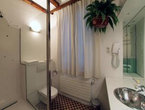 bagno con servizi igienici, lavandino e specchio di Alba Hotel a Barcellona