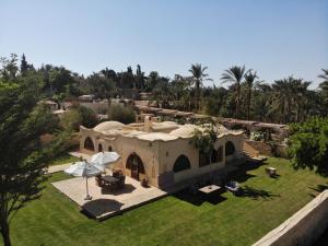 a house with a yard with grass and trees at Kom El Dikka Agri Lodge in ‘Izbat an Nāmūs