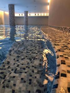 una piscina con suelo de baldosa y 2 columnas en Apartman Paradiso 211, en Vrnjačka Banja