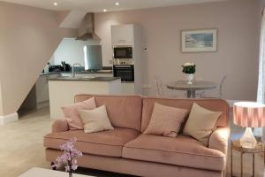 a living room with a brown couch and a kitchen at Kiln Cottage in Fareham