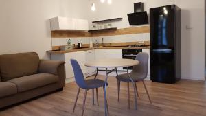 cocina con mesa, sillas y sofá en Avalon apart 1 en Legnica
