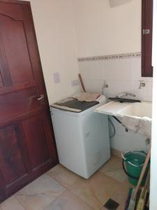 y baño con lavabo y lavadora. en Casa tafi en Tafí del Valle