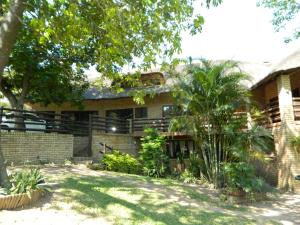 Aloe Cottage في نيلسبروت: مبنى من الطوب وامامه اشجار