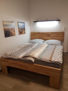 a bedroom with a bed with a wooden headboard at Casa Lago Ferienappartements Steinberg am See in Steinberg am See