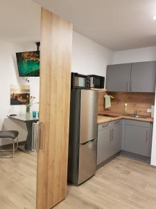 a kitchen with a stainless steel refrigerator and a table at Casa Lago Ferienappartements Steinberg am See in Steinberg am See