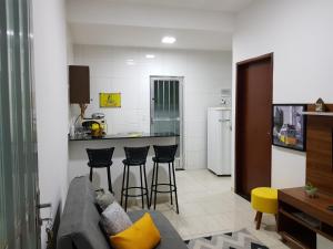 a living room with a couch and a kitchen at Carvalho de Paquetá in Rio de Janeiro