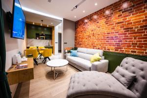 a living room with a couch and a brick wall at DMS Apartments & Suites Sarajevo in Vogošća
