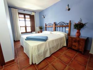a bedroom with a large bed with a wooden headboard at Casa Rural Alquife in Alquife