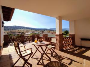 a patio with a table and chairs on a balcony at Casa Rural Alquife in Alquife