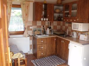 a kitchen with wooden cabinets and a sink at Tündérviola in Szalafő