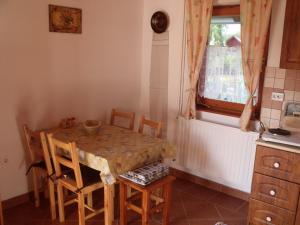 uma cozinha com mesa e cadeiras e uma janela em Tündérviola em Szalafő