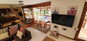 sala de estar con TV de pantalla plana grande en la pared en Green Grass Country, en Punta del Este