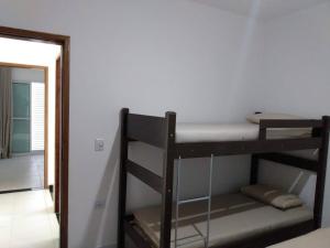 Etagenbett in einem Zimmer mit Spiegel in der Unterkunft Condomínio Villagio II in Caraguatatuba