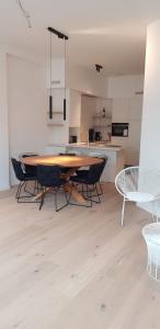 a table and chairs in a room with a kitchen at Nieuwbouwappartement Lippenslaan met 2 slaapkamers - WIFI - 6 personen in Knokke-Heist