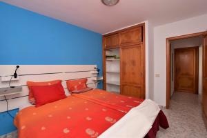 een slaapkamer met een rood bed en een blauwe muur bij Mar y Sol Terraces Sea Views in Punta de Mujeres