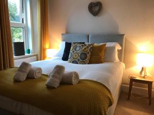 una camera da letto con un grande letto con asciugamani di Tawburn House Boutique B & B a Okehampton