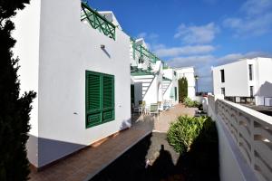 een wit huis met een groene deur en een balkon bij Mar y Sol Terraces Sea Views in Punta de Mujeres