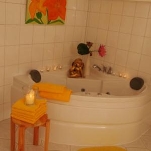 a bathroom with a tub and a table with a candle at Domizil Karin in Bad Bocklet