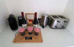 a cutting board with bottles of wine and a toaster at Le Grá Vineyard and Winery in Masterton