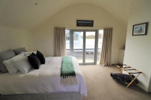 a bedroom with a bed and a sliding glass door at Le Grá Vineyard and Winery in Masterton