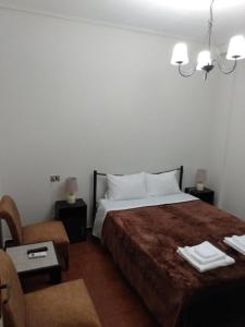 um quarto de hotel com uma cama e uma cadeira em Original House No 2 (central,κεντρικό) em Lárissa