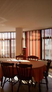 una sala da pranzo con tavolo, sedie e finestre di La Conu Iancu a Drobeta-Turnu Severin