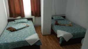 a small bedroom with two beds in it at La Conu Iancu in Drobeta-Turnu Severin