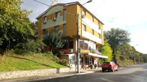 a red car parked next to a building on a street at La Conu Iancu in Drobeta-Turnu Severin
