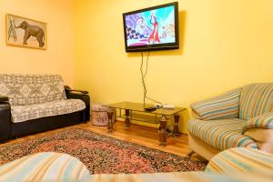 sala de estar con sofá y TV en la pared en Seaside apartment, en Aktau