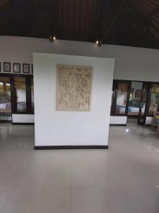 a white wall with a painting on it in a building at Villa Gede Private Guest House in Selemadeg