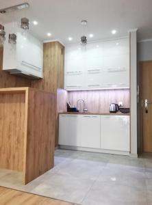 a kitchen with white cabinets and a sink at Apartament Poezja, Kasprowicza 20a in Kołobrzeg