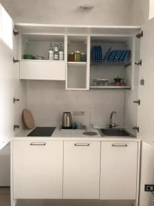 una cocina blanca con armarios blancos y fregadero en Casa Caterina Deluxe Sorrento Coast, en Meta