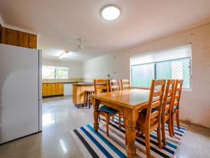 uma sala de jantar com uma mesa de madeira e cadeiras em Croydon Ave 50 Currimundi em Kawana Waters