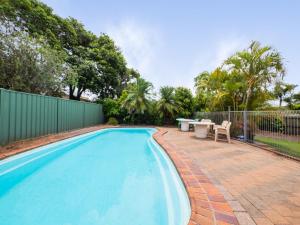 a swimming pool with a table and chairs next to a fence at Croydon Ave 50 Currimundi in Kawana Waters