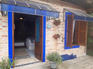 a house with a blue door and a patio at casa da sereia Mermaid Lounge in Ilhabela
