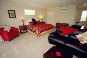 a bedroom with a red bed and a red chair at Marchmont Gardens in Hanmer Springs