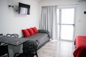 Un dormitorio con una cama con almohadas rojas. en Aurelia, en Valeria del Mar