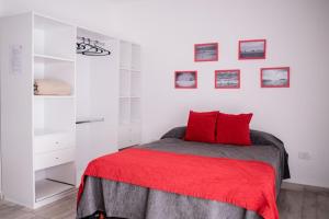 a bedroom with a bed with a red blanket at Aurelia in Valeria del Mar