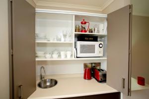 a kitchen with a microwave and a sink at Marchmont Gardens in Hanmer Springs