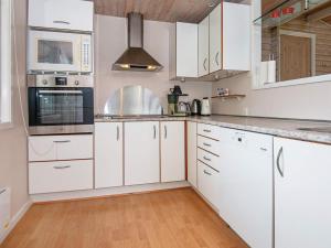 Egeskovにある6 person holiday home in B rkopの白いキッチン(白いキャビネット、電化製品付)
