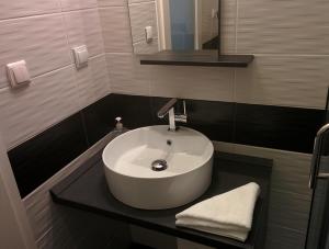 a bathroom with a white sink on a black counter at Major Studió in Hajdúszoboszló