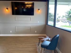 a living room with a blue chair and a tv at Inn at Highway 1 in Lompoc