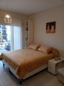 Un dormitorio con una cama grande y una ventana en Monoambiente Libertad 345 en Puerto Madryn