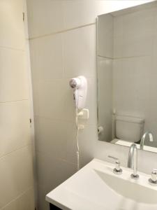 y baño con lavabo blanco y espejo. en Monoambiente Libertad 345 en Puerto Madryn