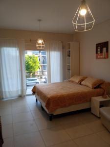 1 dormitorio con cama y ventana grande en Monoambiente Libertad 345 en Puerto Madryn