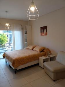 1 dormitorio con 1 cama y 1 silla en Monoambiente Libertad 345 en Puerto Madryn