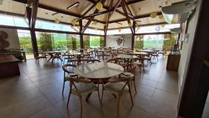 a restaurant with tables and chairs in a room at Malawi Muro Alto - Flat 103H Térreo in Porto De Galinhas