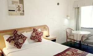 1 dormitorio con 1 cama con almohadas y silla en Espana Motel, en Grafton