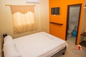 Habitación hospitalaria con cama y baño en Hotel Ágata Manta, en Manta