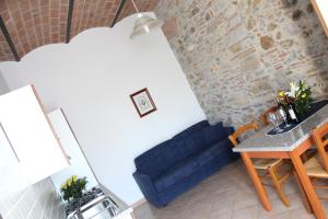 a living room with a blue couch and a table at Casa Vacanze Ribocchi in Campiglia Marittima